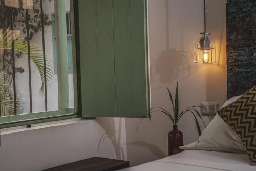 a green cabinet next to a bed with a plant at Waka Hotel Rural in Honda