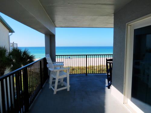 a white chair on a balcony with a view of the ocean at Mariner East in Panama City Beach