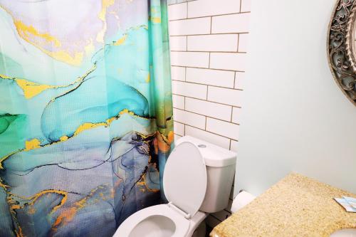 a bathroom with a toilet and a shower curtain at Mariner East in Panama City Beach