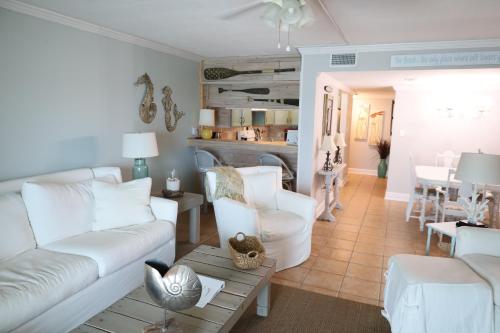 a living room with white couches and a table at Mariner East in Panama City Beach