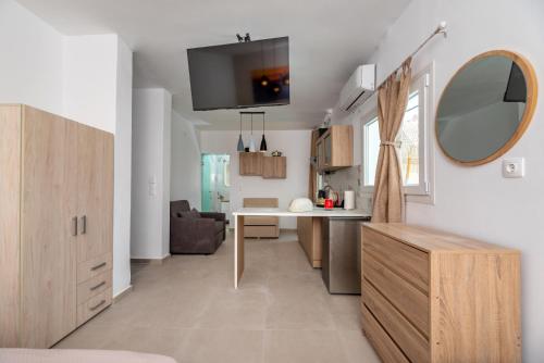 a kitchen and living room with a desk and a mirror at Alexandros mini suites in Santorini
