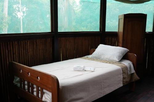 a bedroom with a bed with two towels on it at Ecotone Manu Learning Center, All-Inclusive in Pillcopata