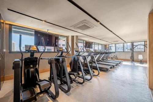 a gym with a row of treadmills and ellipticals at Novíssimo - Skyline Parque Moinhos in Porto Alegre