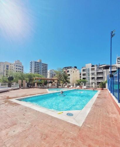 a large swimming pool in a city with buildings at Condo-Panoramic Elevator-10 Min Walk-Rodadero Beach in Santa Marta