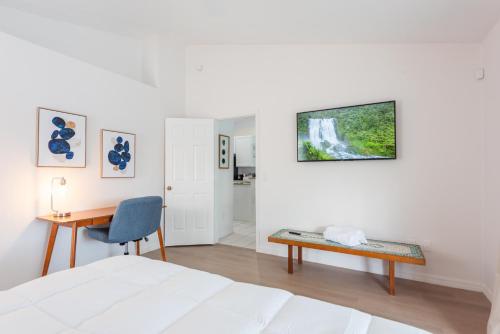 una camera da letto con un letto, una scrivania e un tavolo di Blue Breeze Retreat a Vero Beach