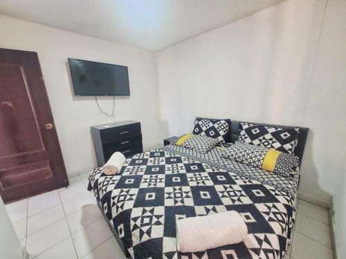 a bedroom with a bed and a tv on the wall at Condo-Panoramic Elevator-10 Min Walk-Rodadero Beach in Santa Marta