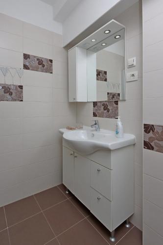 a white bathroom with a sink and a mirror at Apartments with parking space Icici, Opatija - 14155 in Ičići
