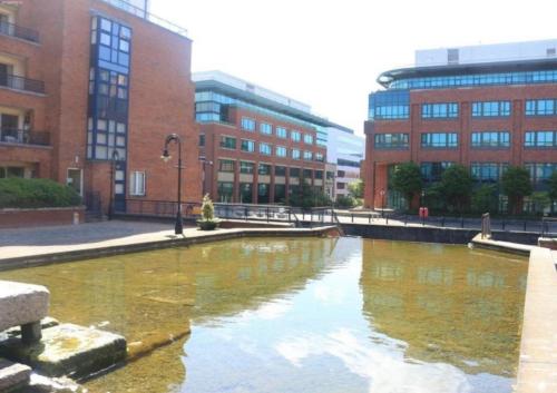 a pond in the middle of a city with buildings at Double Room in a Cozy shared apartment, Custom House Harbour Apartments in Dublin