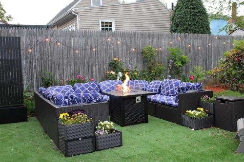 a backyard with a couch and a fire pit at Witch City Retreat with Tiki Bar in Downtown Salem in Salem