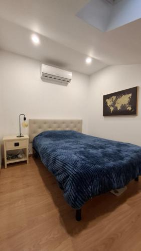 a bedroom with a bed with a blue blanket at Apartamento T1 Arcos de Valdevez - centro da vila in Arcos de Valdevez