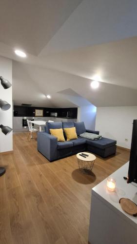 a living room with a blue couch and a table at Apartamento T1 Arcos de Valdevez - centro da vila - 60 m2 total in Arcos de Valdevez