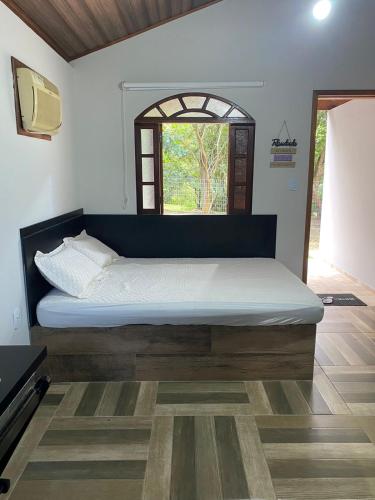 a large bed in a room with a window at Chalés Praias do Sana in Macaé