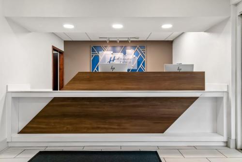 an office lobby with a reception desk with wood at Holiday Inn Express Lapeer by IHG in Lapeer