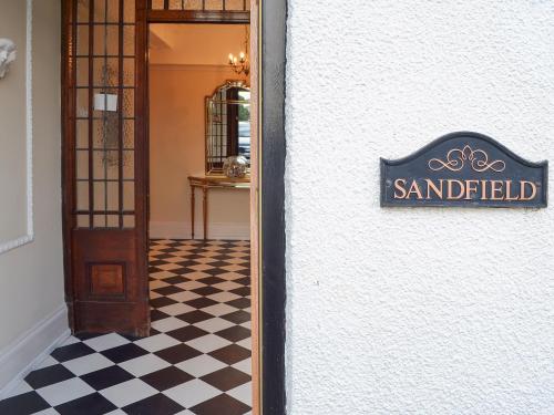 Un cartel en el lateral de un edificio con suelo cuadriculado. en Sandfield The Promenade, en Southport