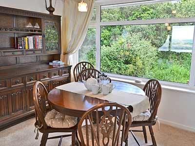 a dining room with a table and chairs and a window at Sheerwater in Appledore