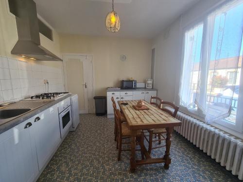 - une cuisine avec une table, une table et des chaises dans l'établissement Maison avec jardin, proche centre-ville et sites touristiques - FR-1-591-59, à Châteauroux