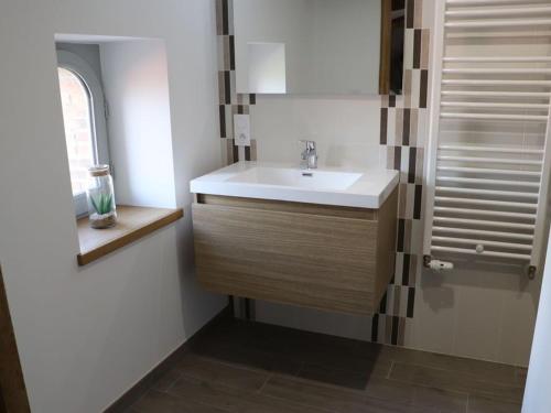 un bagno con un lavandino bianco e una finestra di Gîte 18ème rénové avec piscine couverte, terrasse, loisirs et WiFi – 6 pers. - FR-1-426-432 a Les Herbiers