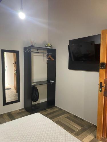 a room with a bed and a mirror and a closet at Chalés Praias do Sana in Macaé