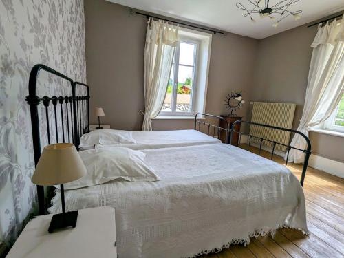 a bedroom with a bed with white sheets and a window at Maison de caractère avec jardin, terrasse et équipements pour grandes familles au Val-d'Ajol - FR-1-589-169 in Le Val-dʼAjol