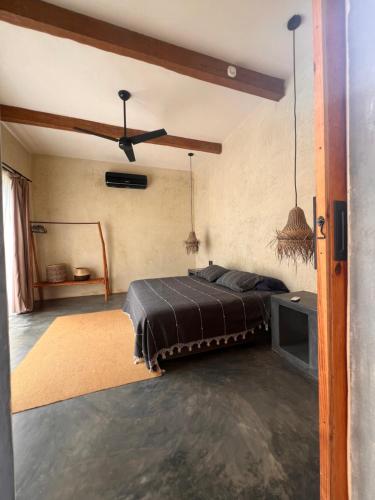 a bedroom with a bed and a ceiling fan at Casa Copal Troncones - Bungalows con Alberca Privada in Troncones