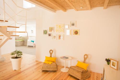 a living room with two chairs and a staircase at CASASUPERTUBOS - Villa 9 in Peniche
