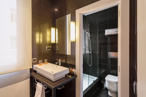 bagno con lavandino, doccia e servizi igienici di Room Mate Mario a Madrid