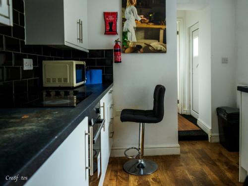 a kitchen with a black counter top and a stool at Bucknall Lodge Hanley Room 2 Double Room En-suite in Stoke on Trent