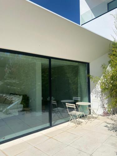a glass extension of a house with a table and chairs at White Olive Villas in Santarém