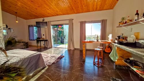 a living room with a kitchen with a counter at Chalé Altos da Represa in Piedade