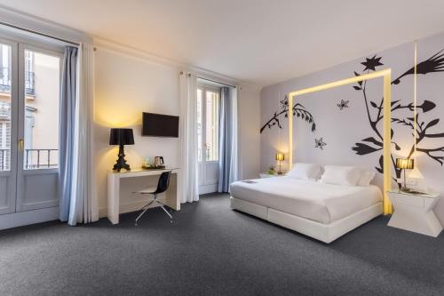 ein Schlafzimmer mit einem weißen Bett und einem Baum-Wandbild in der Unterkunft Room Mate Mario, Madrid in Madrid