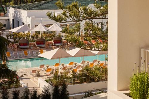 a view of a pool with chairs and umbrellas at Kimpton Los Monteros Marbella by IHG in Marbella