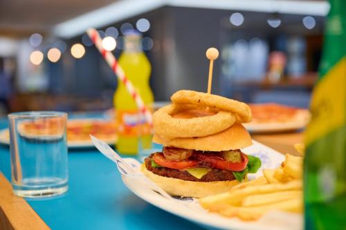 a sandwich with onion rings and french fries on a plate at Holiday Inn Express London Croydon by IHG in Croydon