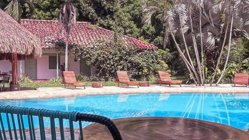 a swimming pool with chairs and a house at Waka Hotel Rural in Honda