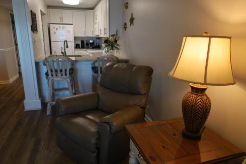 a living room with a couch and a table with a lamp at Mariner East in Panama City Beach