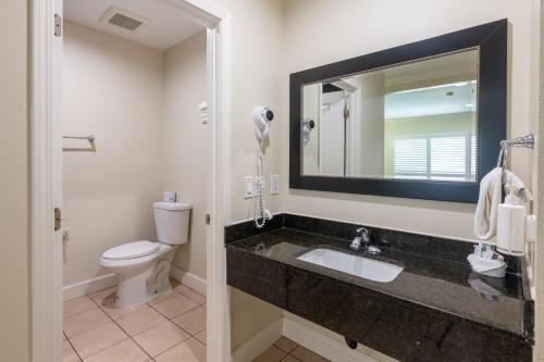 a bathroom with a sink and a toilet and a mirror at Hollywood City Inn in Los Angeles