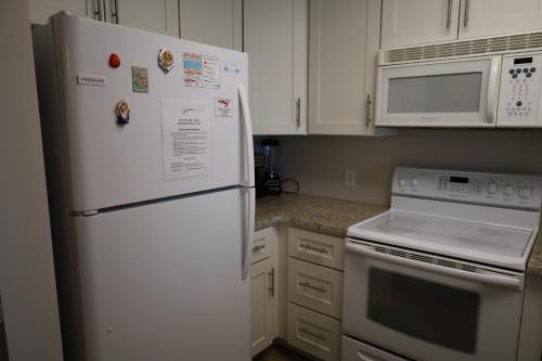 a kitchen with white cabinets and a white refrigerator at Mariner East in Panama City Beach