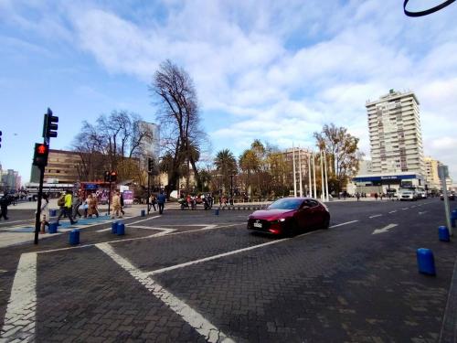 a red car on a street in a city at Alojamiento céntrico a pasos de Tiendas in Temuco