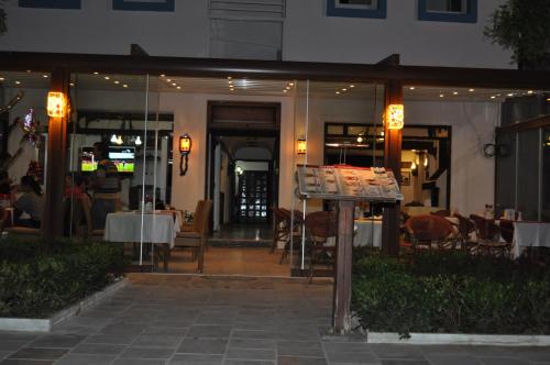 Un restaurante con mesas y sillas y un cartel. en Dinc Pension, en Bodrum City