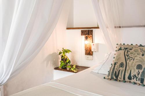 a bedroom with a bed with white curtains at Waka Hotel Rural in Honda