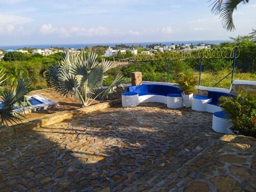 a patio with three blue and white benches and the ocean at Liz&Mar Glamping in Tubará