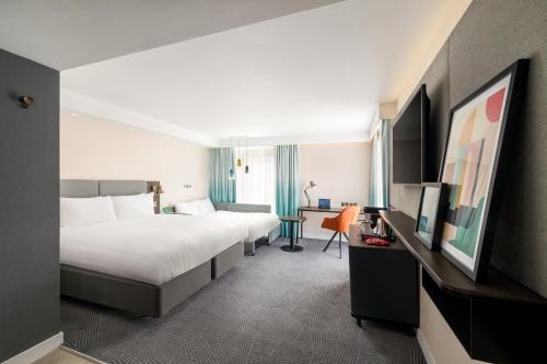 a hotel room with two beds and a desk at Holiday Inn Lincoln by IHG in Lincoln