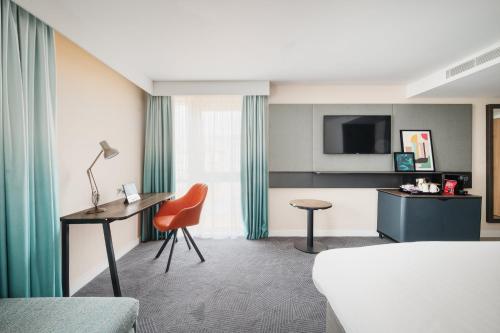 a hotel room with a bed and a desk at Holiday Inn Lincoln by IHG in Lincoln