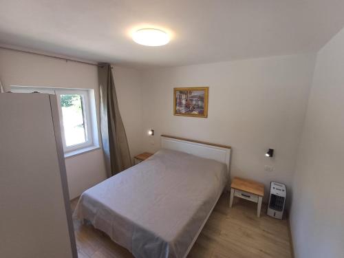 a small bedroom with a bed and a window at Apartman Aurora Salakovci in Labin