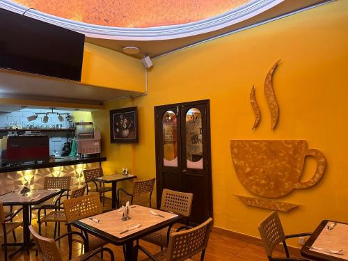 a restaurant with tables and chairs and a yellow wall at Hotel Colonial in Teziutlán