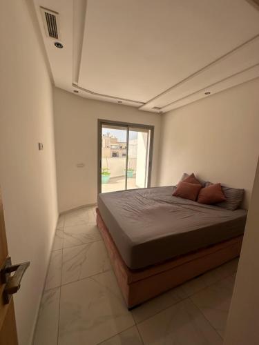 una cama en una habitación con ventana en Central Kenitra Loft, en Kenitra