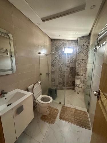 Un baño con inodoro, ducha y lavabo. en Central Kenitra Loft, en Kenitra