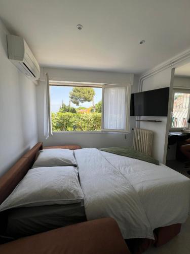 une chambre avec un grand lit avec une fenêtre dans l'établissement Gourmet studio - charm & comfort, à La Seyne-sur-Mer
