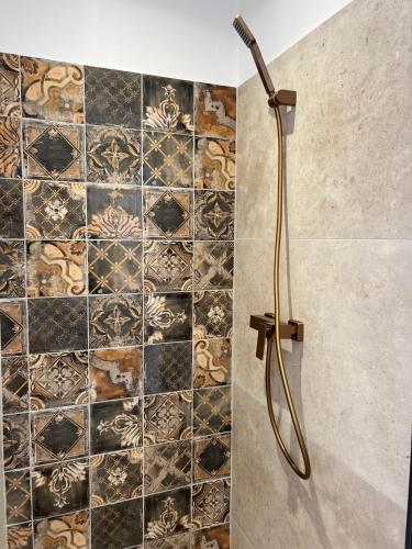 une douche dans une salle de bain avec un mur carrelé dans l'établissement Gourmet studio - charm & comfort, à La Seyne-sur-Mer