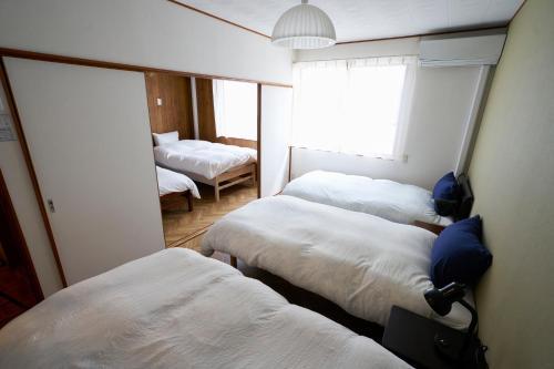 Una cama o camas en una habitación de 最大10名様 徒歩で海1分 ｺﾝﾋﾞﾆ30秒 長谷駅6分 極楽寺駅6分 大仏12分 貸切一軒家96ｍ2 閑静な住宅地