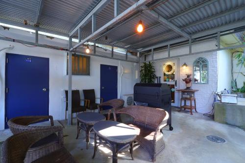 a room with chairs and tables and a blue door at Shirahama Hotel in Nago